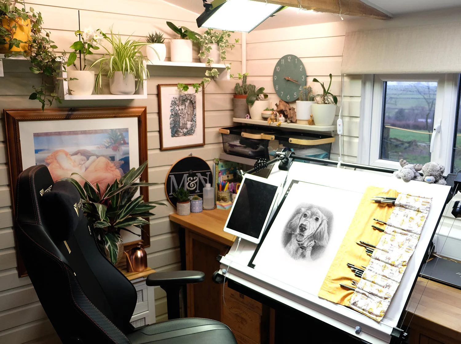 Melanie's drawing desk with art supplies and a laptop, ready for creative work.