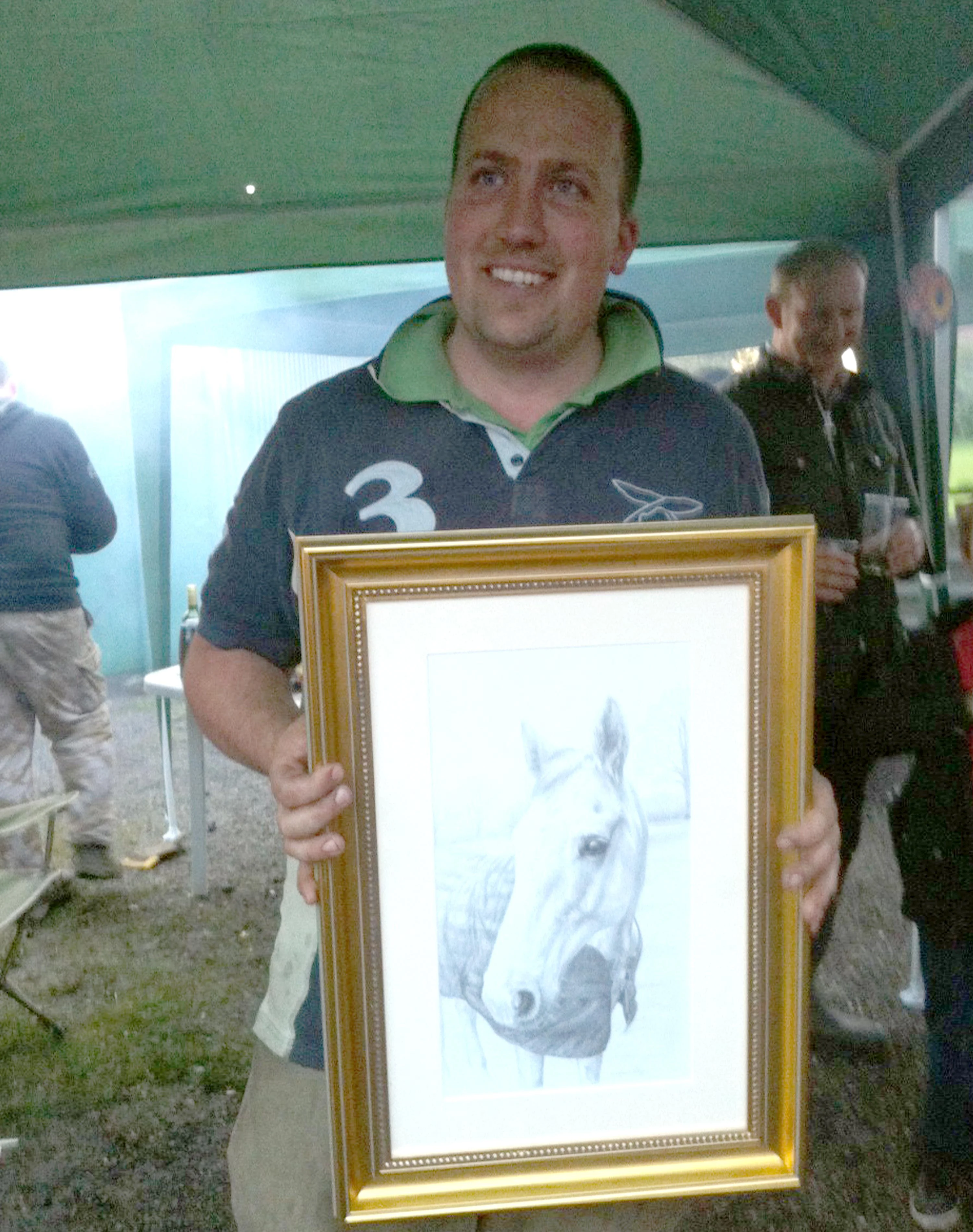 Donna's husband holding the framed pencil portrait of his horse, Al, at his birthday celebration.